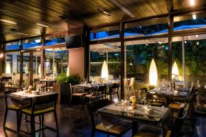 a restaurant with tables and chairs and large windows at SANA Berlin Hotel in Berlin