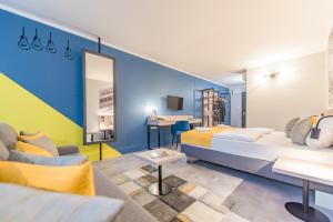 a hotel room with two beds and a couch at Impulso Fashion Hotel in Budapest
