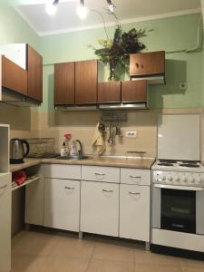 a kitchen with white cabinets and a stove at Duga Apartments in Novi Sad