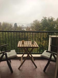 a wooden table and two chairs on a balcony at Duga Apartments in Novi Sad