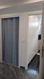 a room with a sliding glass door with a curtain at Cosy studio proche la Défense in La Garenne-Colombes