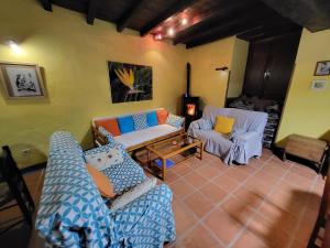 sala de estar con 2 sofás y chimenea en Casa Rural La Severina en Hervás