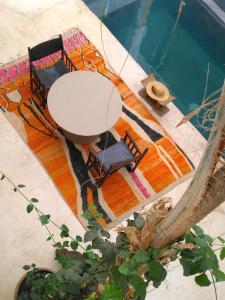 una vista aérea de una mesa con sillas y una piscina en Riad Dar Massai, en Marrakech