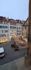 two cars parked in front of a large building at HITrental Zur Metzgern Apartments in Lucerne