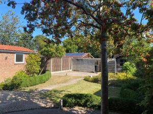 a house with a tree in a yard at Zeehuis Zuidzande in Zuidzande