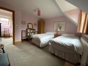 1 dormitorio con 2 camas y escalera en Jasmine Cottage, en Frome
