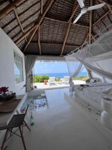 a bedroom with a bed and a view of the ocean at Mar-Me-Quer, Eco Beach Retreat in Inhambane