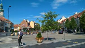 a man walking down a street in a town at Belváros Apartmanház Sopron in Sopron