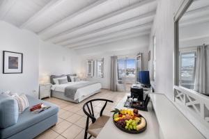 a living room with a bed and a table with a bowl of fruit at Deliades Hotel in Ornos +37 photos