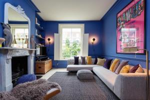 a blue living room with a couch and a fireplace at Veeve - A Room with a Hue in London