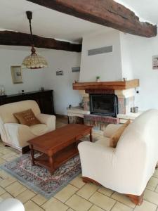 sala de estar con muebles blancos y chimenea en Gîte Les Aubins - Bord de Mer - Cotentin, en Bretteville-sur-Ay