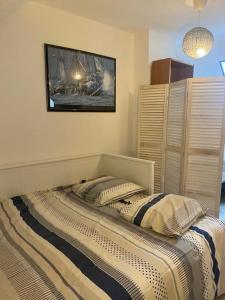 1 cama en un dormitorio con una foto en la pared en Gîte Les Aubins - Bord de Mer - Cotentin, en Bretteville-sur-Ay