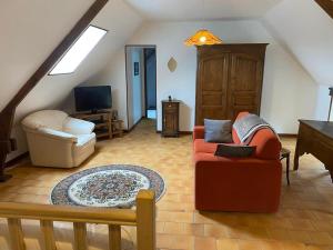 sala de estar con sofá y TV en Gîte Les Aubins - Bord de Mer - Cotentin, en Bretteville-sur-Ay