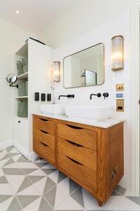 a bathroom with a sink and a mirror at Veeve - A Room with a Hue in London