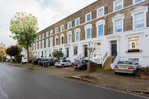 a large brick building with cars parked in front of it at Veeve - A Room with a Hue in London