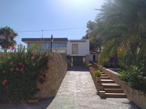 una casa con un passaggio in pietra davanti di Nuza, Villa con Piscina y Barbacoa a El Campello