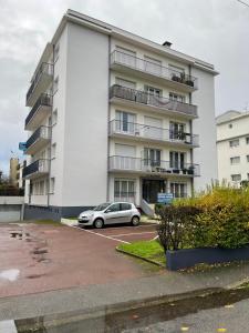 a car parked in a parking lot in front of a building at Saint Nazaire - Le Sembat - Proche mer - Wifi fibre in Saint-Nazaire