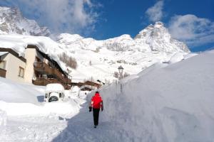 a person walking through a snow covered mountain at Skichaletcervinia 7p Ski in Ski out aan piste nr. 5 uitzicht Matterhorn in Breuil-Cervinia