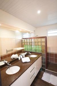 a bathroom with two sinks and a shower at 972D1 - Résidences Tamarin Haut de villa Tamarin 200m2 vue panoramique in Rivière-Salée