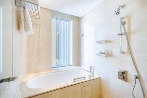 bagno con vasca e finestra di Studio Marina View Access to Marina Mall a Dubai