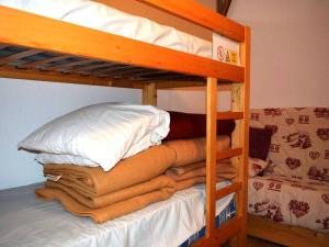 um beliche com uma pilha de cobertores e almofadas em Appartement Le Grand-Bornand, 3 pièces, 6 personnes - FR-1-241-100 em Le Grand-Bornand