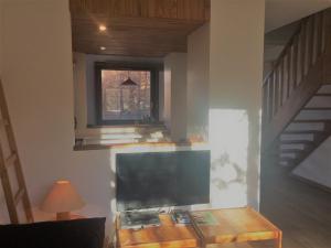 sala de estar con mesa y TV en Appartement 3 pièces 6 couchages à Risoul, calme et proche des pistes - FR-1-330-310, en Risoul