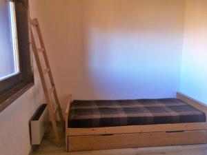 Un dormitorio con una cama y una escalera junto a una pared. en Appartement 3 pièces 6 couchages à Risoul, calme et proche des pistes - FR-1-330-310, en Risoul