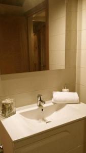 a bathroom with a white sink and a mirror at APARTAMENTOS RURALES El Llagar de Cue in Llanes