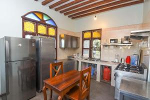 a kitchen with a table and a stainless steel refrigerator at Majani Breeze in Nungwi