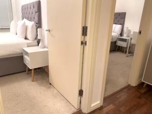 ein Zimmer mit einem Schlafzimmer mit einem Bett und einem Spiegel in der Unterkunft Centra St albans city 2bedRoom 2 shower ROOM APT free parink in St Albans