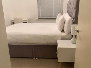 ein Schlafzimmer mit einem Bett und einem Tisch und einem Fenster in der Unterkunft Centra St albans city 2bedRoom 2 shower ROOM APT free parink in St Albans