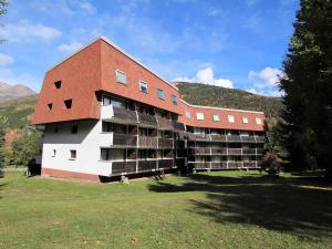 un grand bâtiment avec une pelouse devant lui dans l'établissement Studio cosy avec coin montagne, proche pistes et commodités, piscine et jardin, La Salle-les-Alpes - FR-1-330F-98, à Serre Chevalier