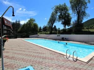 a swimming pool with two people in the water at Studio fonctionnel 4 pers, à 50m des pistes, proche commodités, piscine extérieure en été. - FR-1-330F-89 in Serre Chevalier