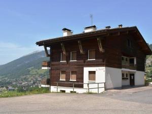 ein großes Holzhaus mit einem Berg im Hintergrund in der Unterkunft Appartement Le Grand-Bornand, 5 pièces, 8 personnes - FR-1-241-197 in Le Grand-Bornand