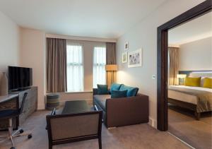 um quarto de hotel com uma cama e uma sala de estar em Staybridge Suites London-Vauxhall, an IHG Hotel em Londres