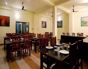 a dining room with tables and chairs in a restaurant at Hotel Holiday Highlights in Rāmnagar