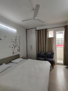 大諾伊達的住宿－FACULTY HOUSE- Cosy Lounge Near Expo Mart，卧室设有一张白色大床和一扇窗户。