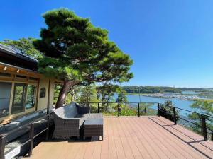 eine Terrasse mit einem Baum, einem Tisch und Stühlen in der Unterkunft Hitachinaka Villa DAN - ひたちなか 暖 - in Hitachinaka
