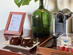 uma mesa com duas canecas de café e um vaso verde em Villa Várzea - Charming Suite em Várzea