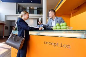 a man and a woman standing at a reception counter at Atlantic Hotel Universum in Bremen