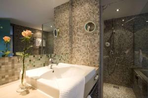 a bathroom with a sink and a shower at Atlantic Hotel Universum in Bremen