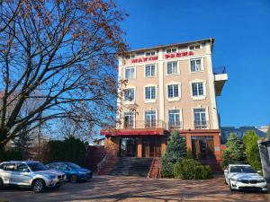 a building with cars parked in front of it at Maxim Pasha Hotel in Chişinău