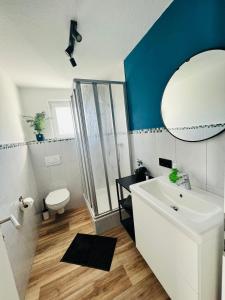 een badkamer met een witte wastafel en een spiegel bij Himmlische Weite 3 in Schweinfurt