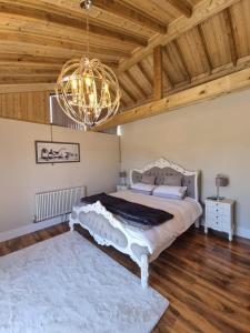 um quarto com uma cama grande e um lustre em Immaculate 4-Bed Private Luxury Lodge near York em York