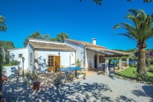 El Port的住宿－Pollensa - 40788 Mallorca，前面有棕榈树的白色房子