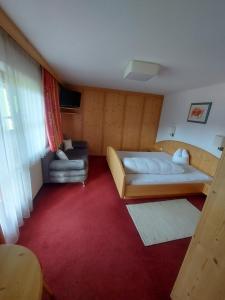 ein kleines Zimmer mit einem Bett und einem Stuhl in der Unterkunft Haus Theresia Alpbach in Alpbach