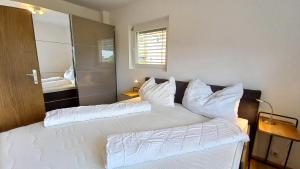 a bedroom with two beds with white pillows at MONA Haus KMB Seeblick Appartement am Ossiacher See mit direktem Seezugang, Hallenbad in Bodensdorf