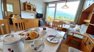a kitchen and living room with a table with food on it at MONA Haus KMB Seeblick Appartement am Ossiacher See mit direktem Seezugang, Hallenbad in Bodensdorf +29 photos
