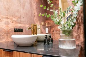 łazienka z umywalką i wazą z kwiatami w obiekcie Dandelion Apartment - LoftAffair w Krakowie +37 zdjęć