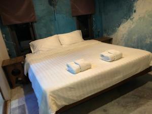 un letto bianco con due cuscini sopra di Beach Way Apartment a Ko Samui
